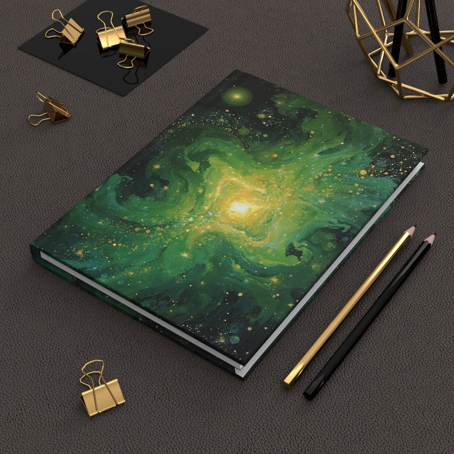 Notebook with galaxy design on a dark surface with stationery items