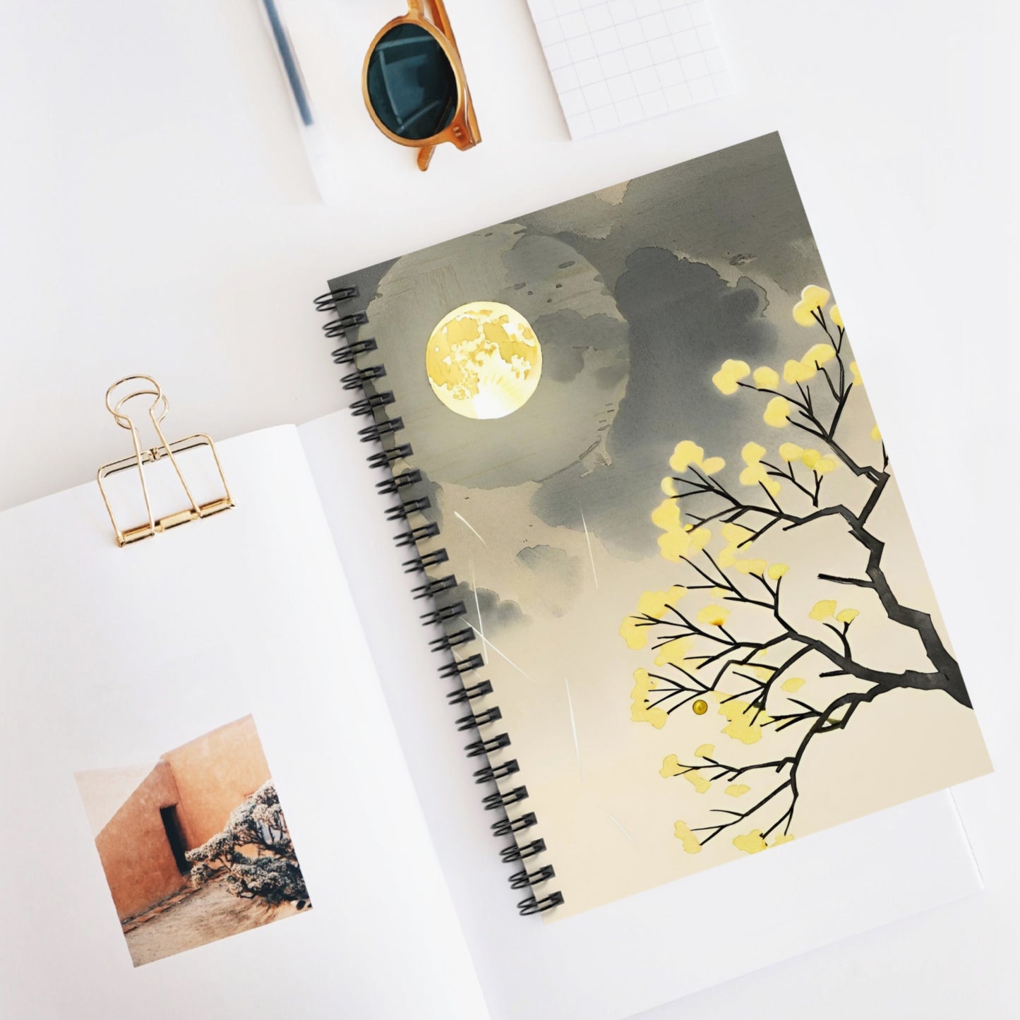Notebook with a moon and tree design on a white surface