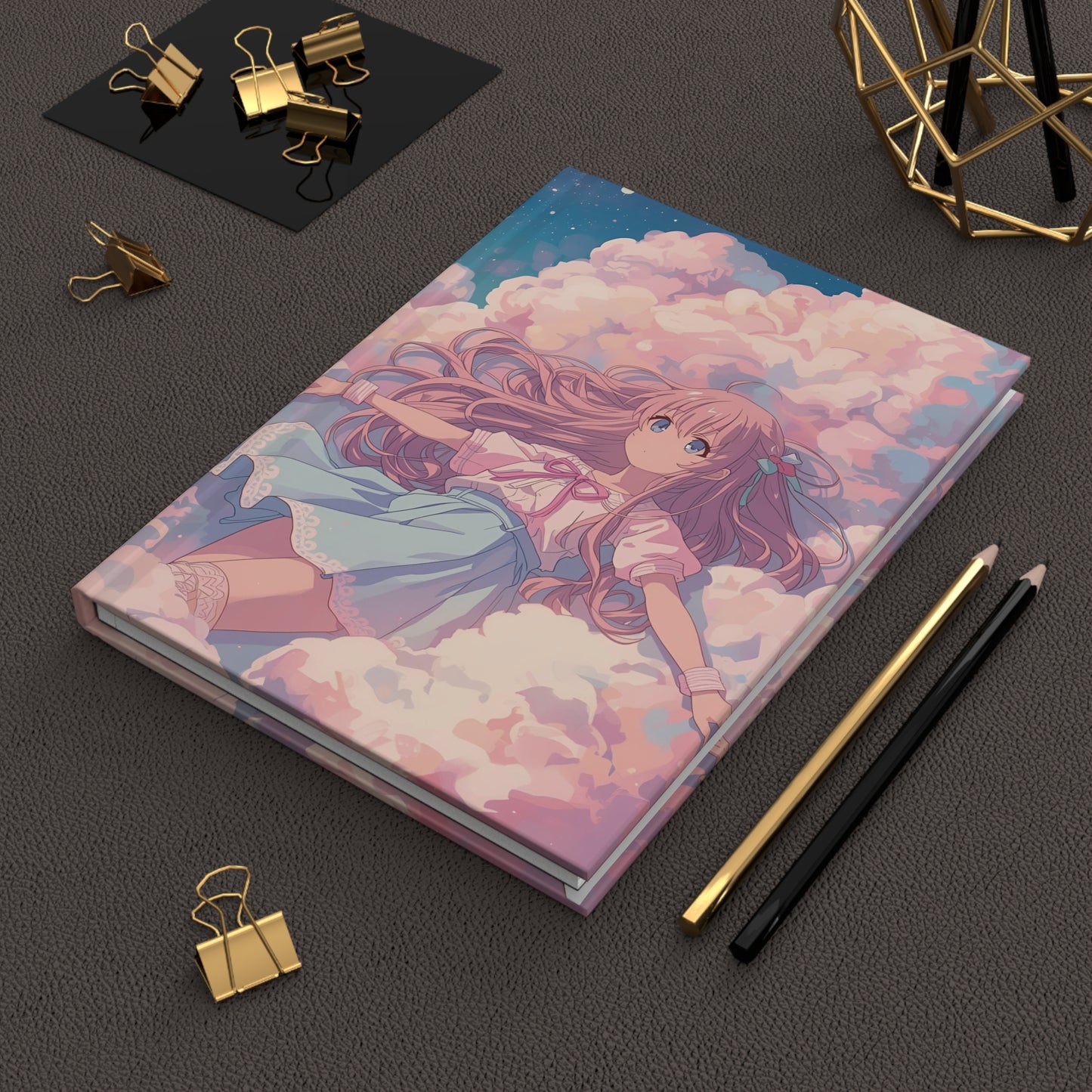 Notebook with an illustration of a girl on clouds, surrounded by stationery items on a dark surface.