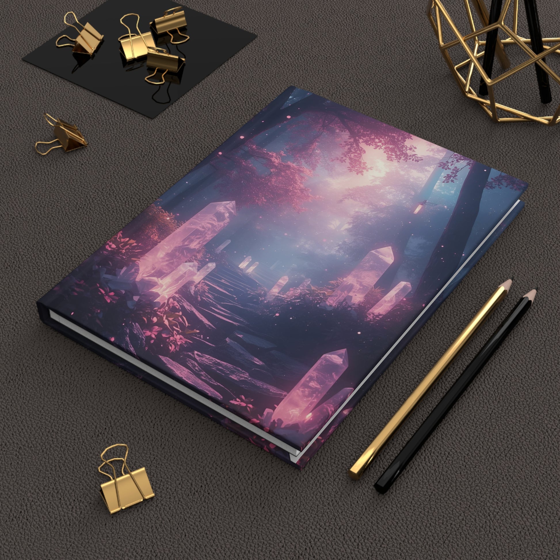 Notebook with a fantasy design on a dark surface with stationery items.