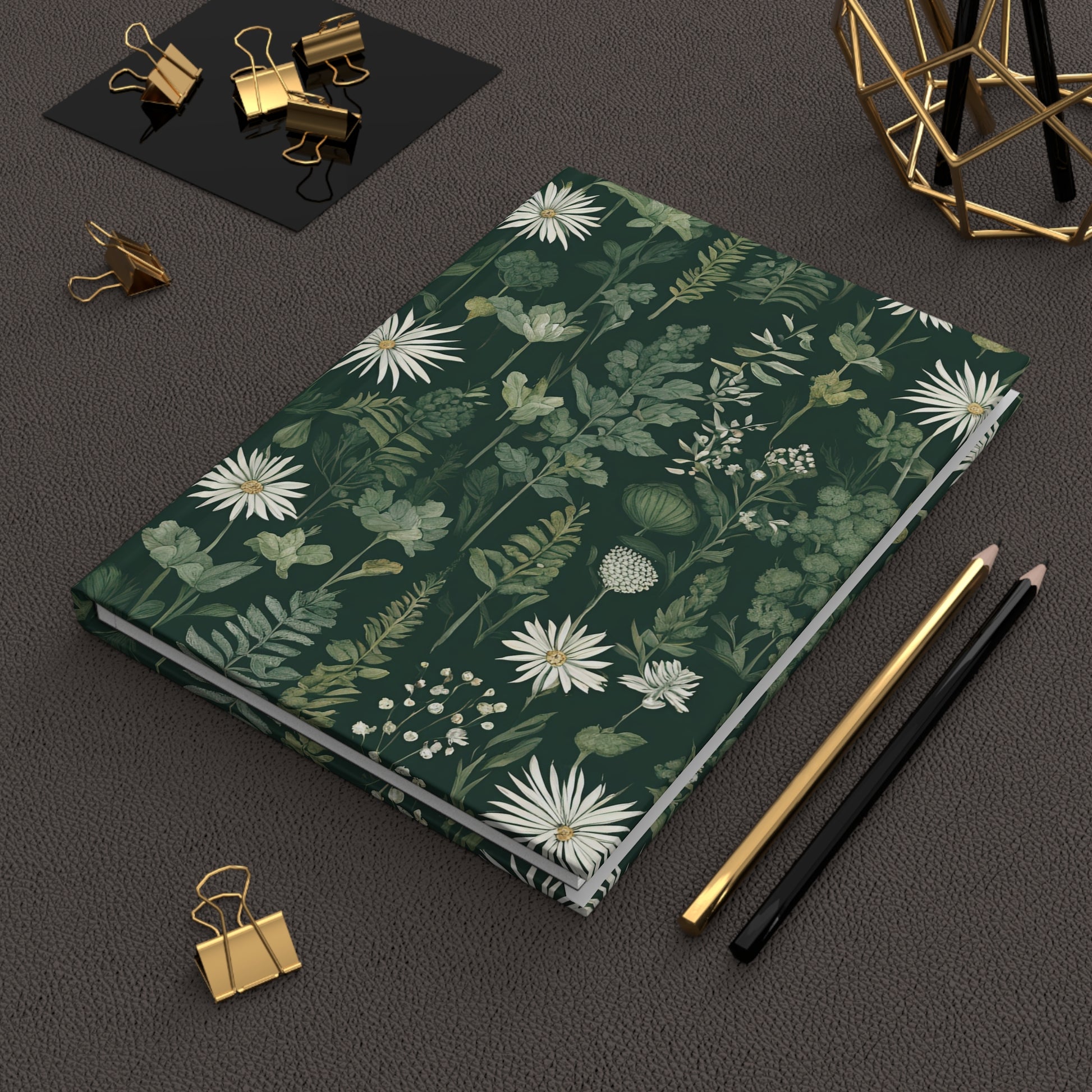 Floral notebook on a dark surface with office supplies