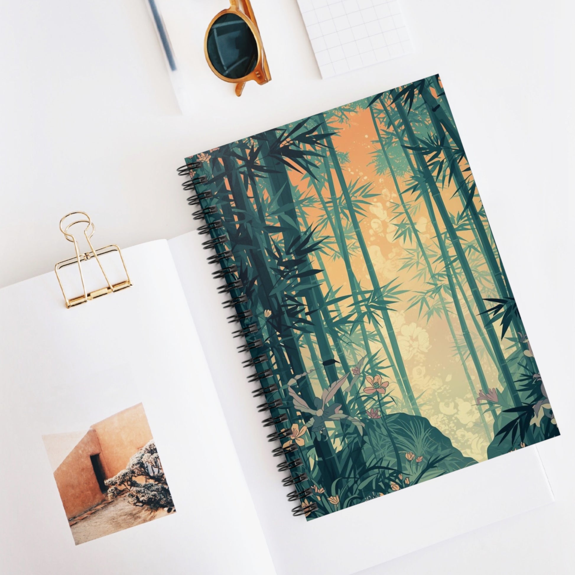 Notebook with bamboo design on a white surface with a photo and clip.