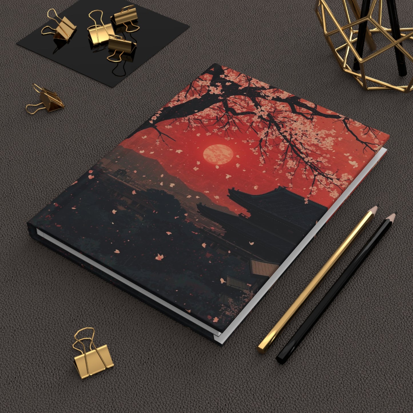 Notebook with a wolf and moon design on a dark surface with stationery items.