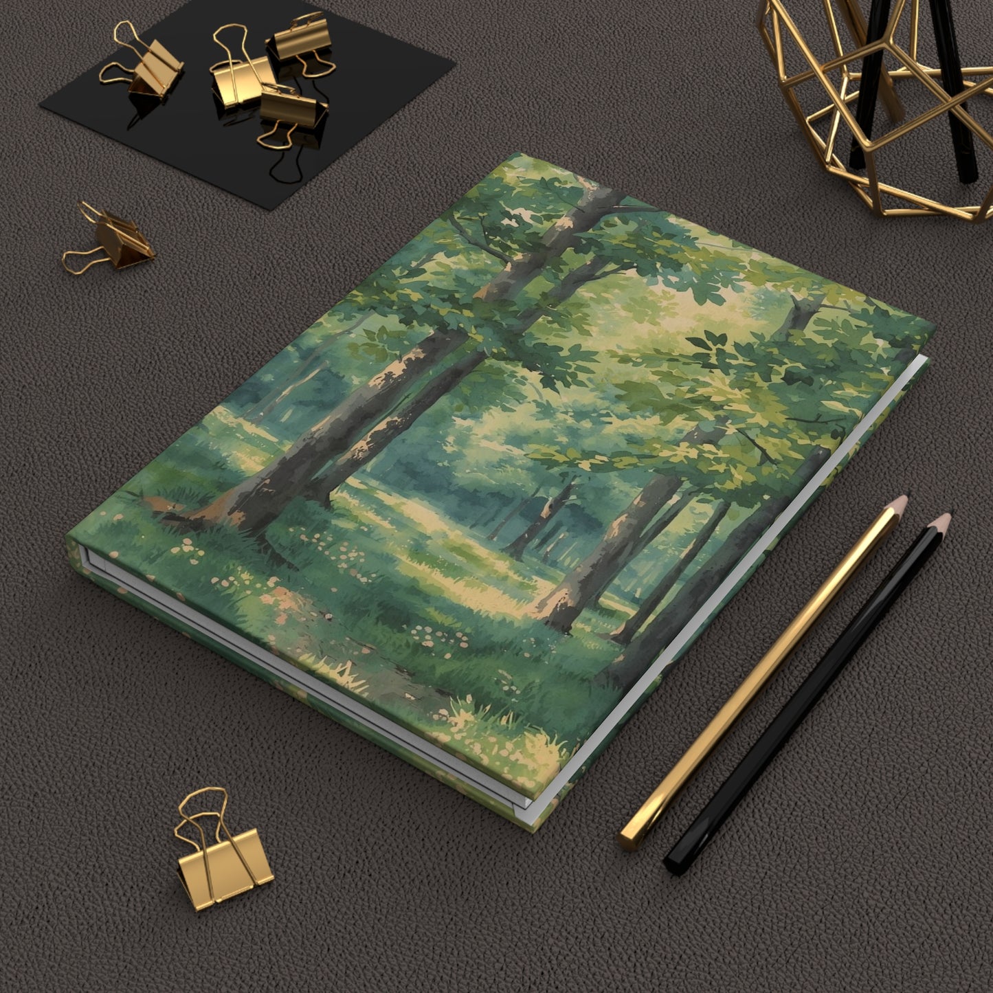 Notebook with forest design on a dark surface with office supplies