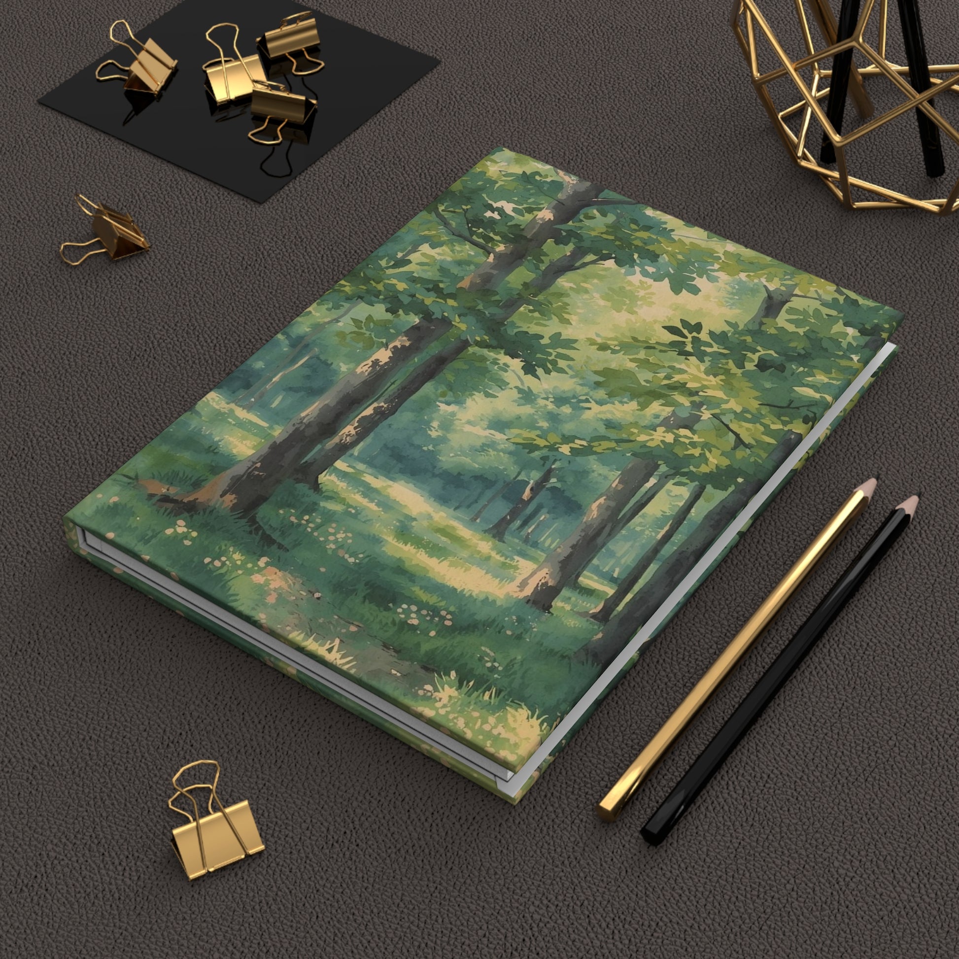 Notebook with forest design on a dark surface with office supplies