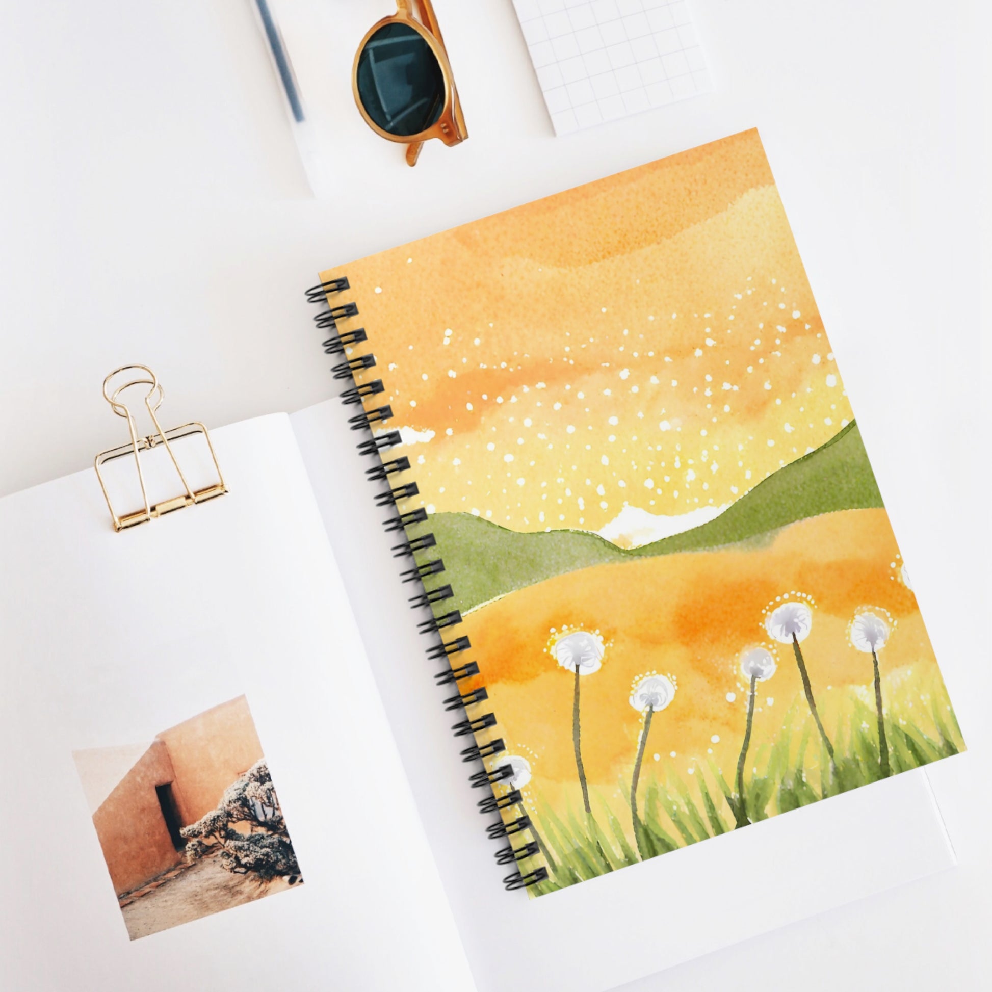Notebook with a dandelion design on a white surface