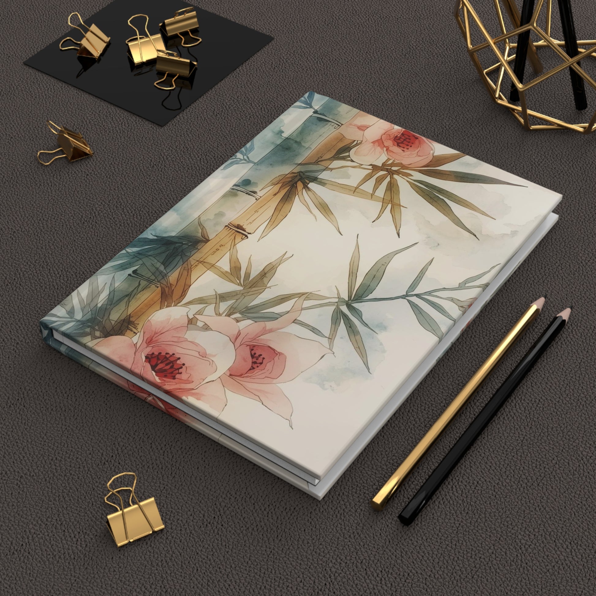 Floral notebook on a dark surface with stationery items